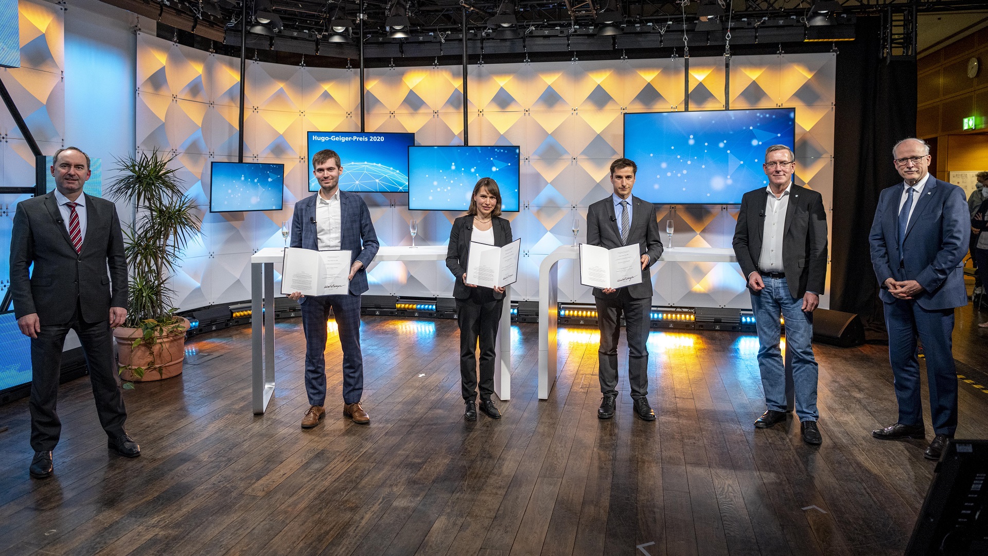 Minister Hubert Aiwanger mit den Hugo-Geiger-Preisträgern: Dr. Simon Fichtner, Dr. Annelie Schiller, Dr. Christian Kalupka. Zu den Gratulanten gehörten auch die Fraunhofer-Vorstandsmitglieder Andreas Meuer und Prof. Alexander Kurz (v.l.n.r.).