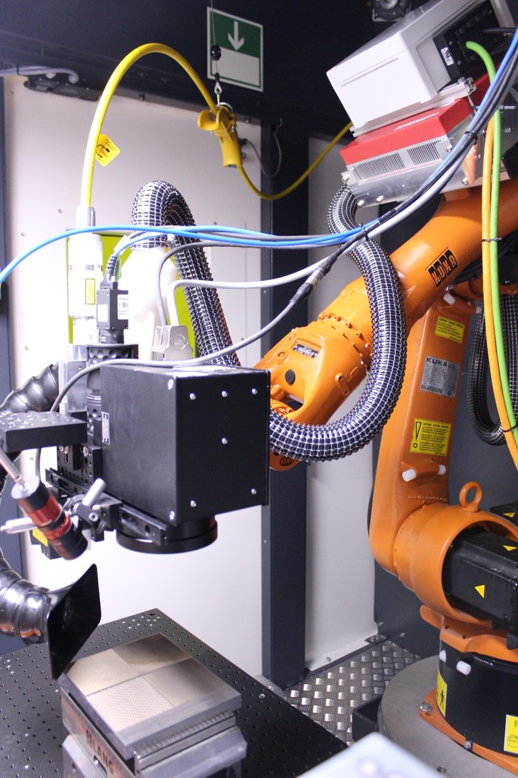 KUKA robot with installed laser scanner tool, measuring equipment and laser beam source.